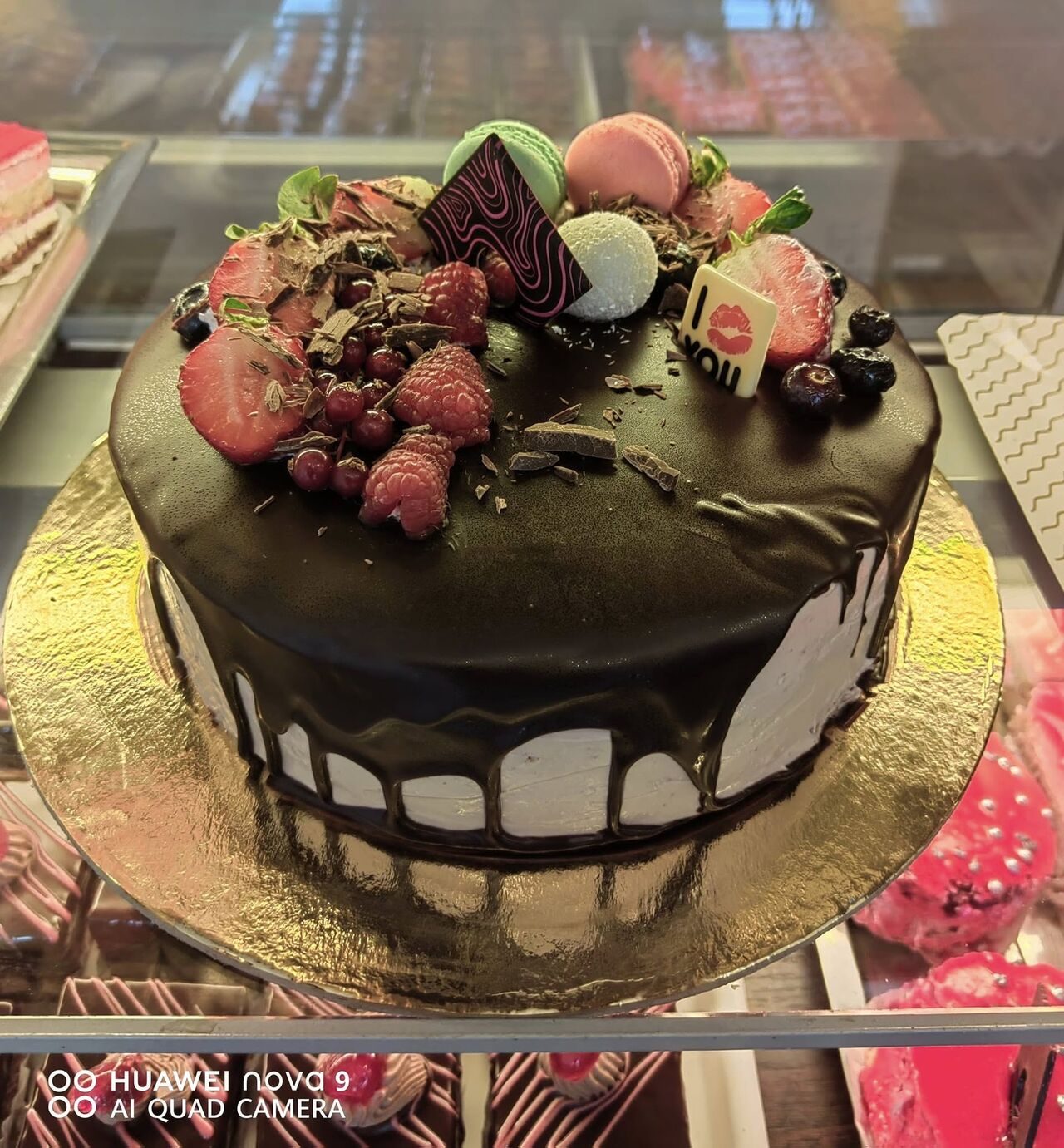 Tort cu glazură de ciocolată neagră, căpșuni, zmeură și macarons