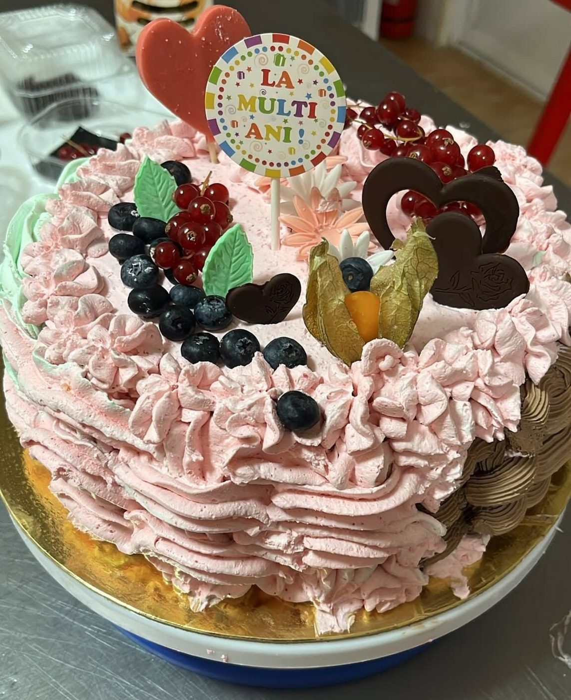 Tort cu frișcă roz, fructe de pădure și decor „La mulți ani”